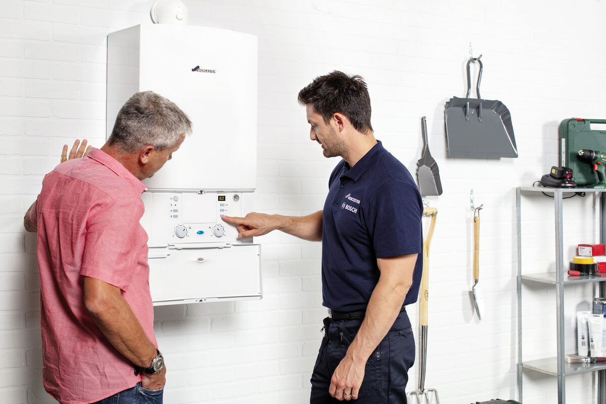 Gas engineer explaining boiler to customer
